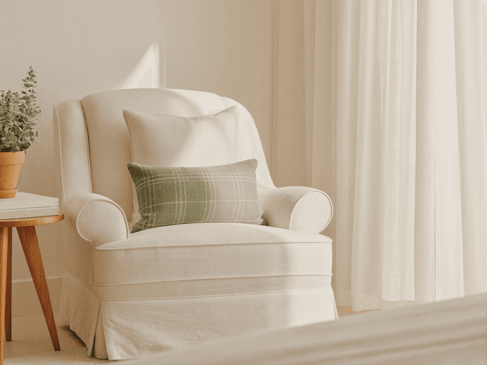 Coin de cabinet chaleureux, fauteuil en lin crème, coussin sauge et eucalyptus, lumière douce